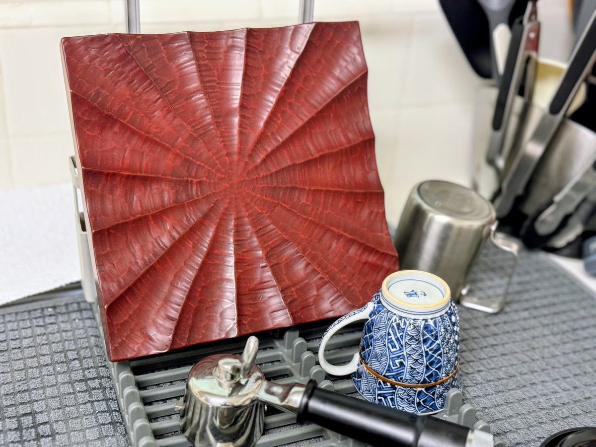 A Kamakura-bori plate on a kitchen drying rack